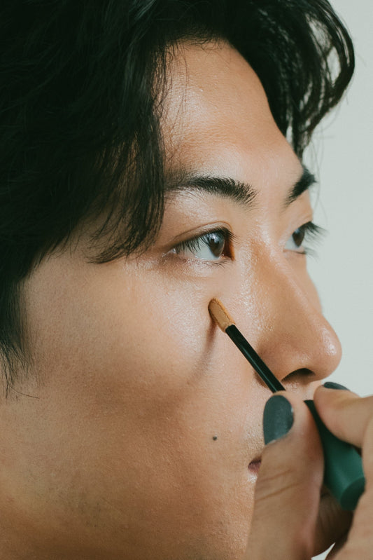 A man applying Kint Concealer to his under-eye area.