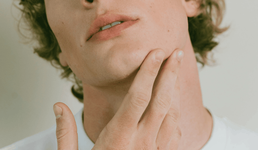 A man touching his jaw after applying Kint nail strengthener